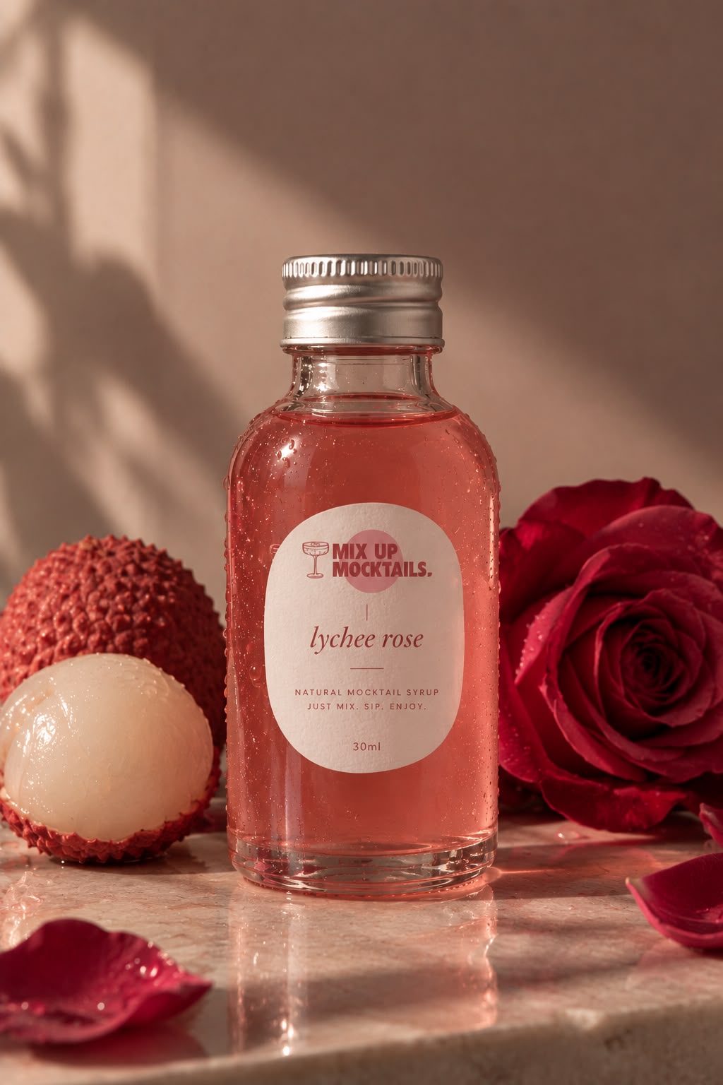 Lychee Rose Mocktail Mixer bottle with lychees and a red rose
